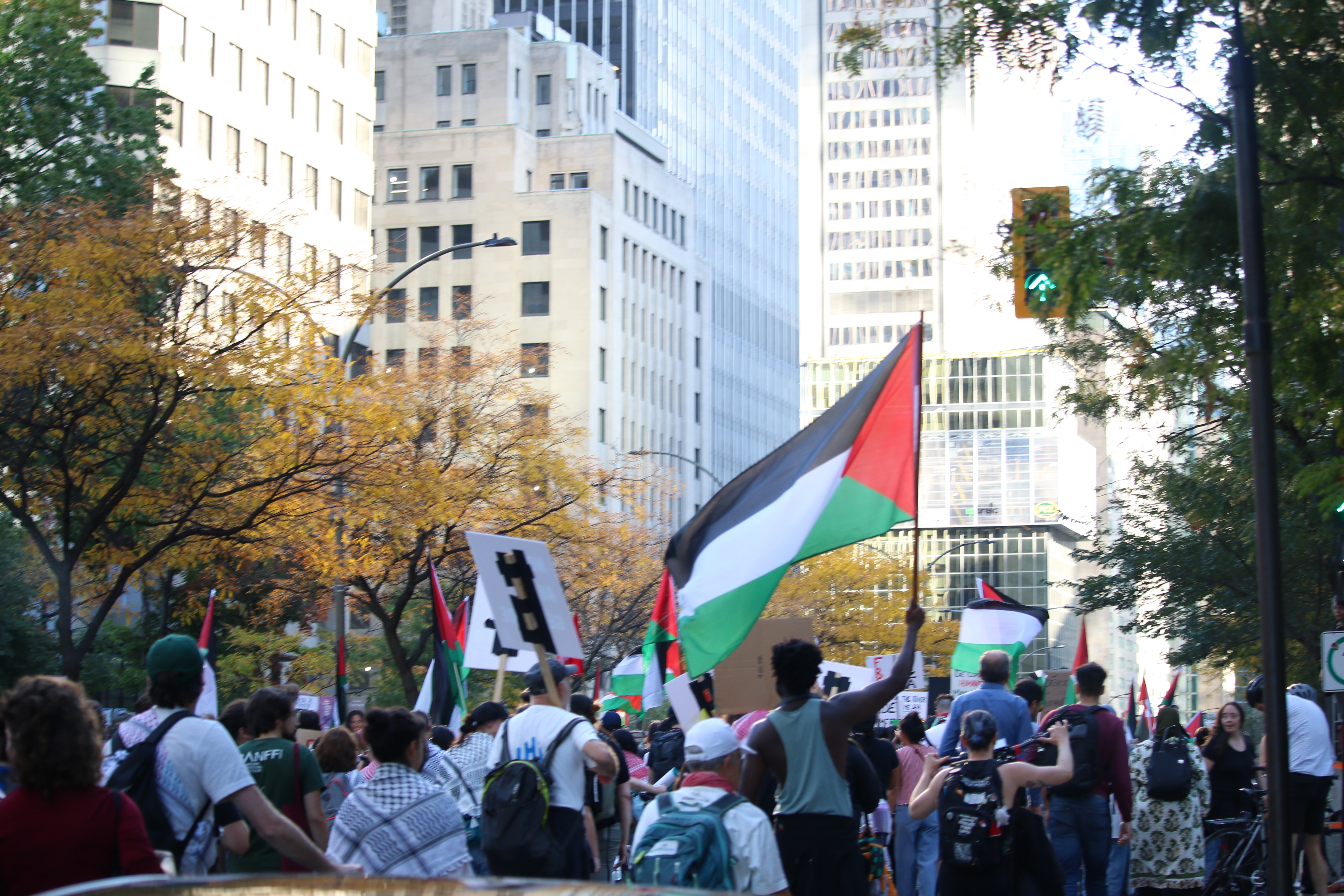 Une personne tient un drapeau palestinien à une manifestation à Montréal